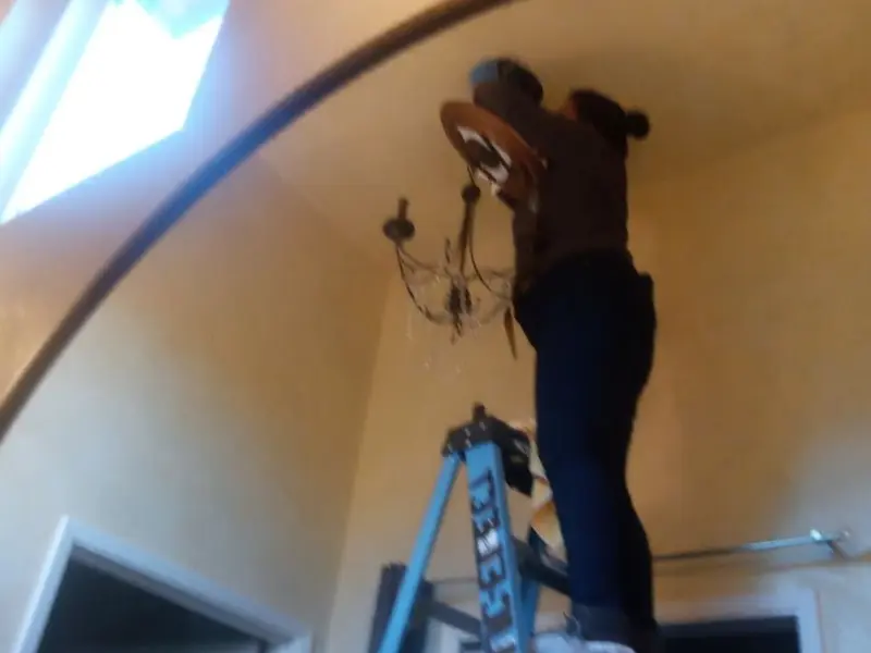 Electrician installing a chandelier in a Walnut Creek residence